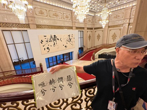 導覽員向同學解說展示於國家音樂廳大廳內的大型書法作品。
